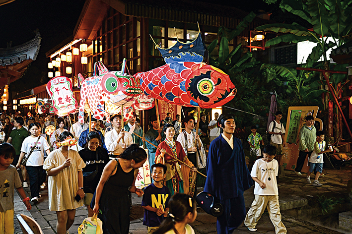 2025年8月27日，在黄山市休宁县齐云山生态文化旅游度假区，游客们观赏非遗鱼灯巡游 周牧摄/本刊