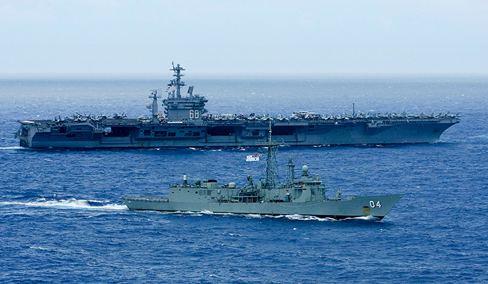在美国夏威夷瓦胡岛以北海域，参加“环太平洋”军演的一艘澳大利亚海军舰只（前）和美国海军“尼米兹”号航母一同航 行的资料照片