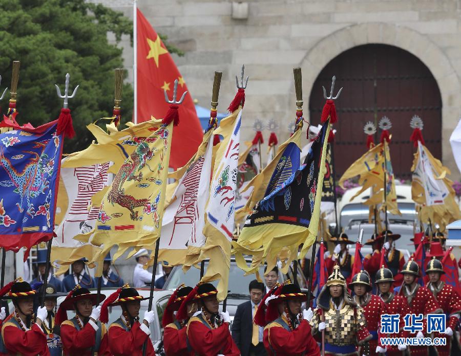 7月3日，韓國(guó)總統(tǒng)樸槿惠在青瓦臺(tái)總統(tǒng)府舉行隆重儀式，歡迎中國(guó)國(guó)家主席習(xí)近平對(duì)韓國(guó)進(jìn)行國(guó)事訪問。這是習(xí)近平的車隊(duì)在身著民族服裝的韓國(guó)禮儀隊(duì)伍引導(dǎo)下駛?cè)肭嗤吲_(tái)。新華社記者丁林?jǐn)z  